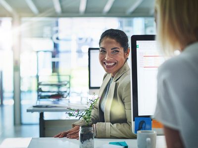 woman looking back at her coworker in the office - tungsten network enrolment