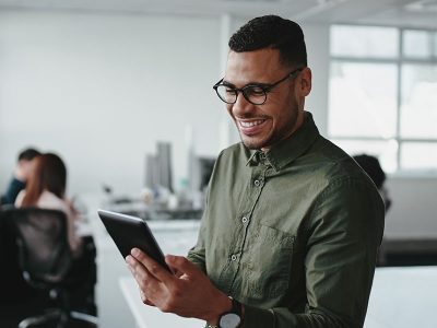 man in glasses looking at a tablet in an office - tungsten network enrolment