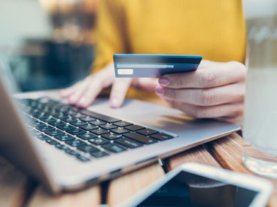 A person typing bank card details on a laptop
