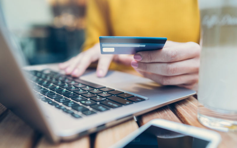 A person typing bank card details on a laptop