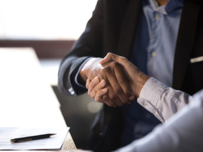 Close up african businessman shaking hands with client