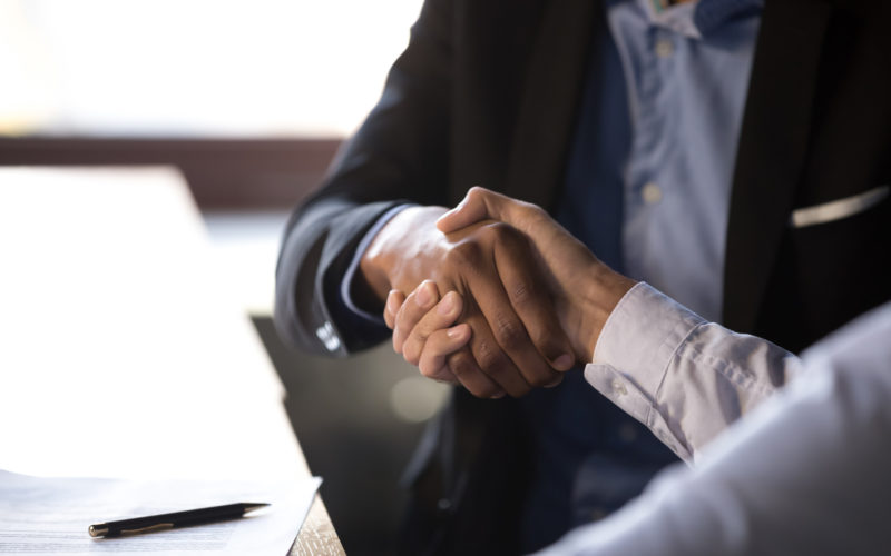 Close up african businessman shaking hands with client