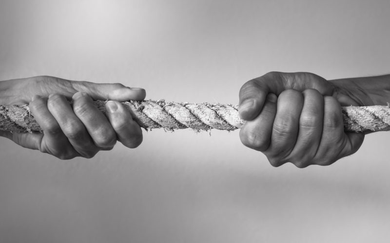 Hands pulling rope playing tug of war