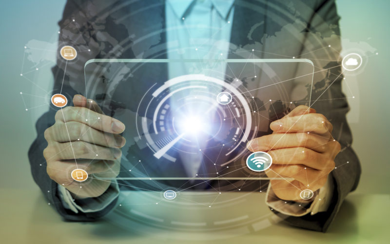 man looks at transparent monitor panel that indicates technological graphics, IoT(Internet of Things), ICT(Information Communication Technology), CPS(Cyber-Physical Systems), abstract