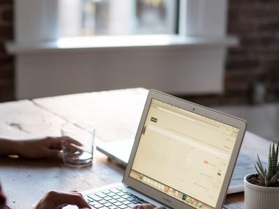 man sitting at a wooden table with laptop open - Tungsten Network