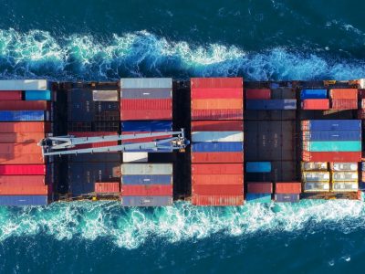 Aerial view Top speed with beautiful wave of container ship full load container with crane loading container for logistics import export or transportation concept background.