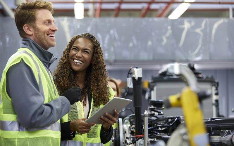Smiling engineers standing with digital tablet