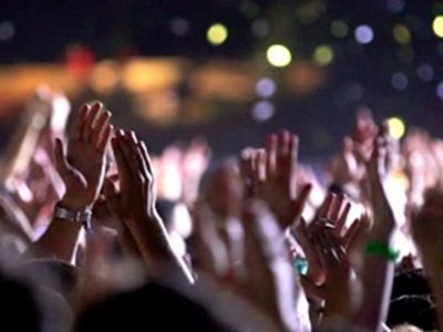A close up look at the raised hands clapping at an event