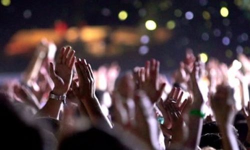A close up look at the raised hands clapping at an event