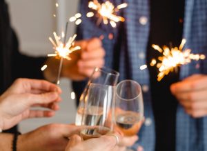 people celebrating New Year's Eve with champagne and sparklers