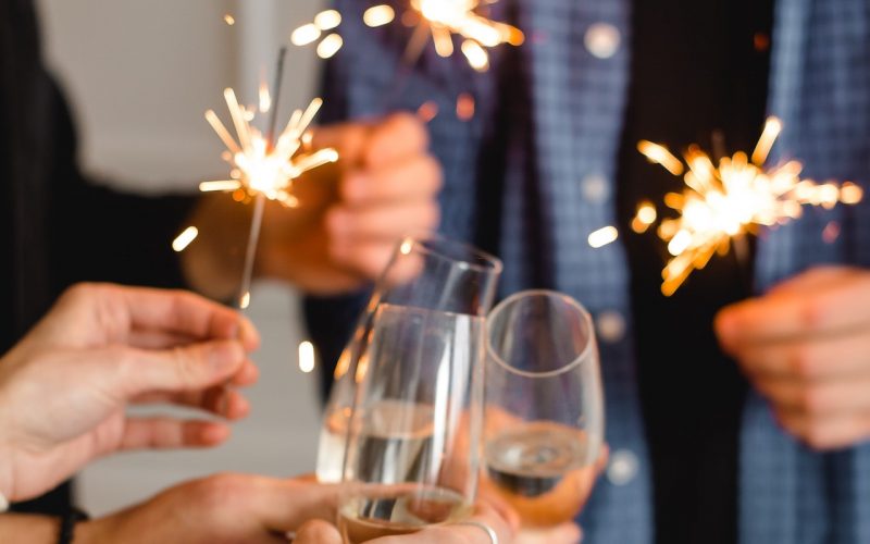 people celebrating New Year's Eve with champagne and sparklers