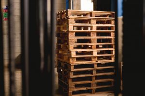 wood shipping crates in dark, empty warehouse, symbolizing the effect of COVID on supply chains, and the need for P2P automation