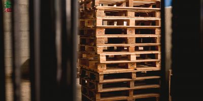 wood shipping crates in dark, empty warehouse, symbolizing the effect of COVID on supply chains, and the need for P2P automation