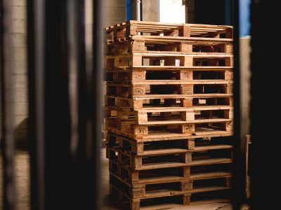 wood shipping crates in dark, empty warehouse, symbolizing the effect of COVID on supply chains, and the need for P2P automation