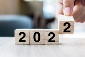 hand turning wooden calendar to 2022