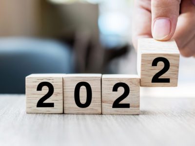 hand turning wooden calendar to 2022